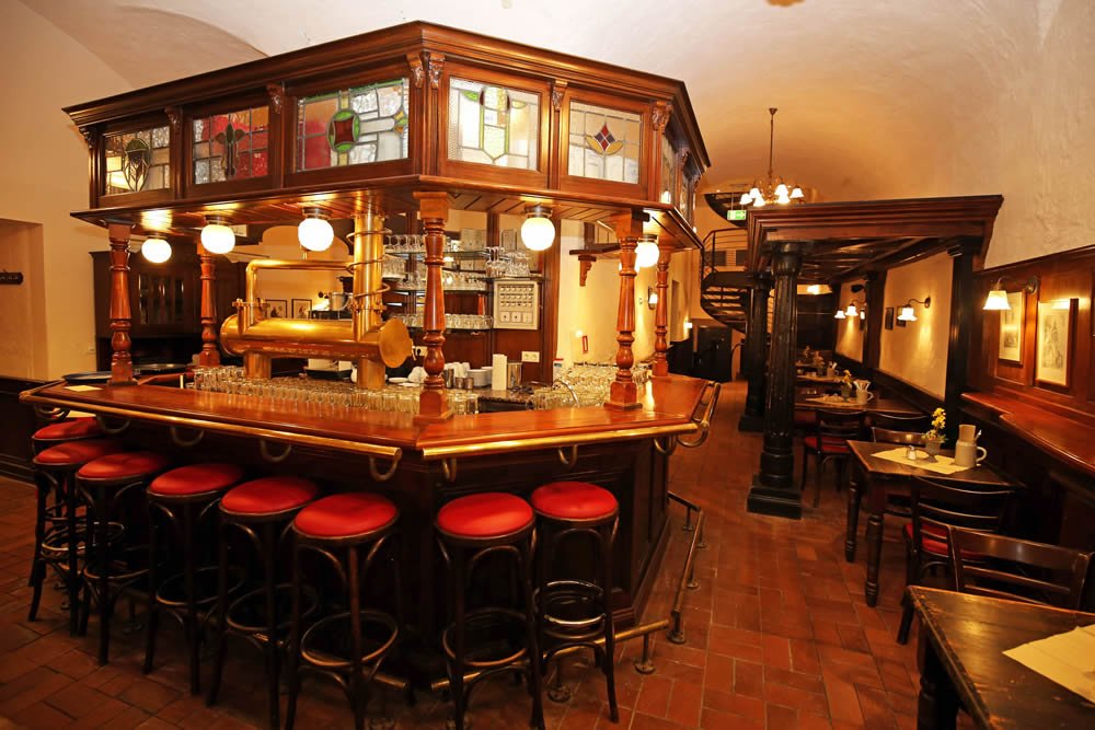 Historischer Schankraum im Barthels Hof mit geschnitztem Holztresen und Buntglas